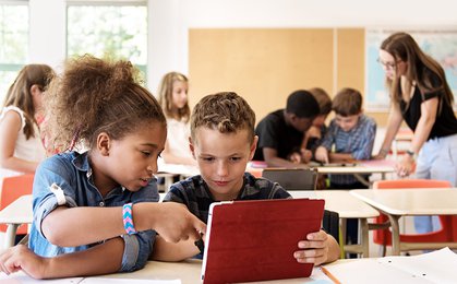 Boy in blue t-shirt holding red tablet computer