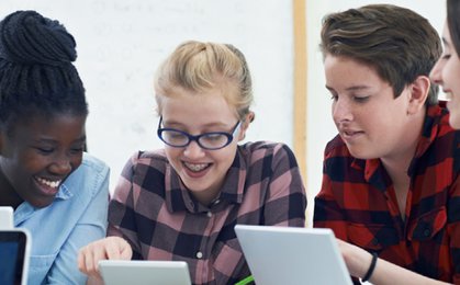 Boy in black framed eyeglasses holding white tablet computer